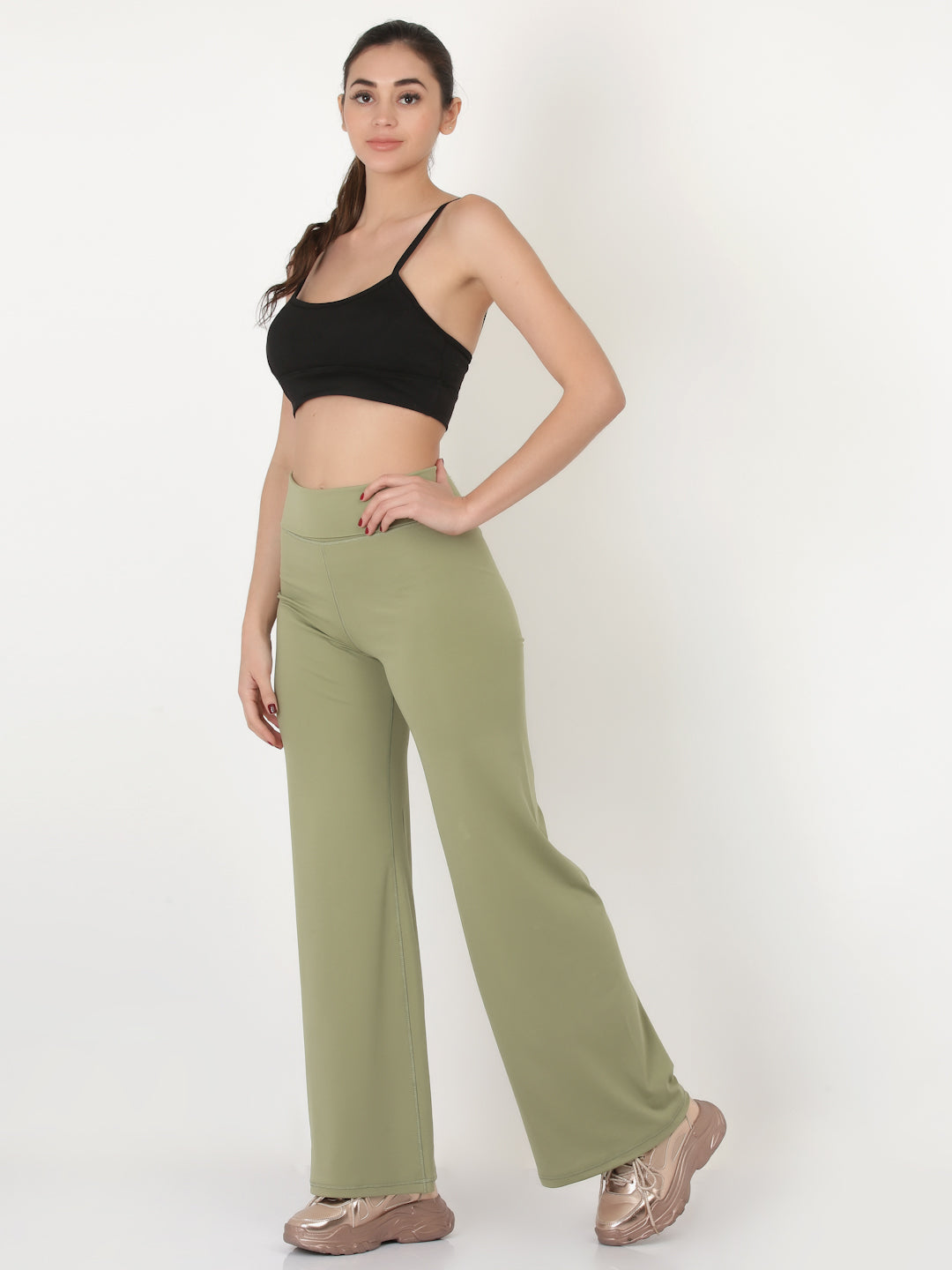 A pair of green flared high-rise full-length yoga pants on a female model.