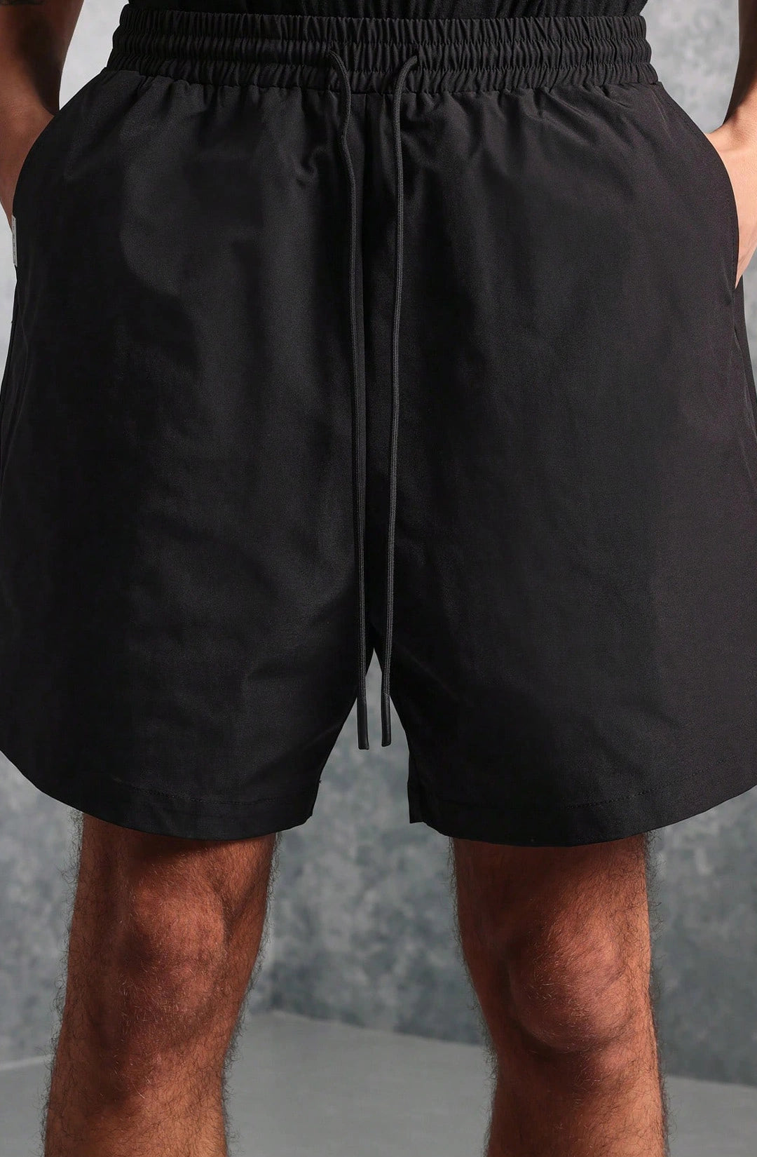 Black shorts worn by a person against a neutral background