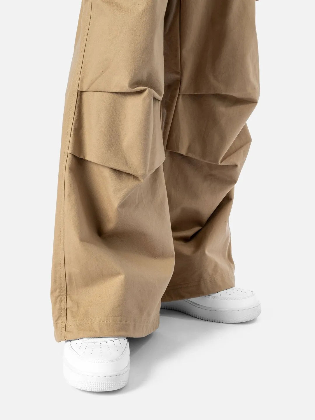 Beige cargo pants with adjustable drawstrings and pockets on a white background