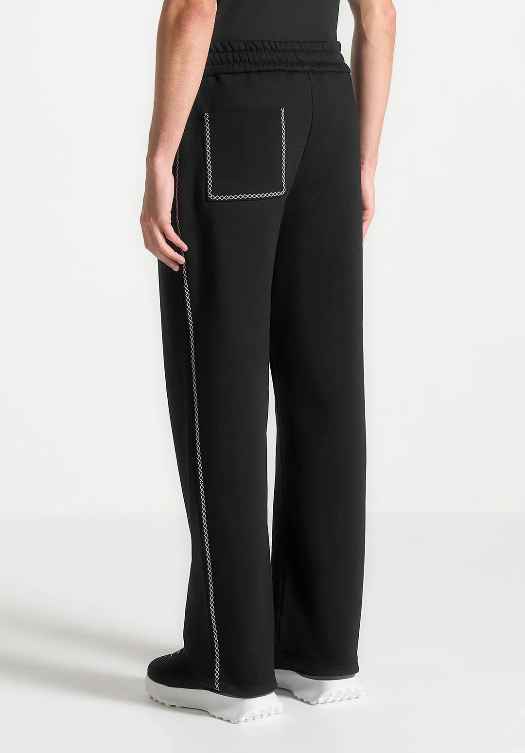 Black pants with white stitching on a white background