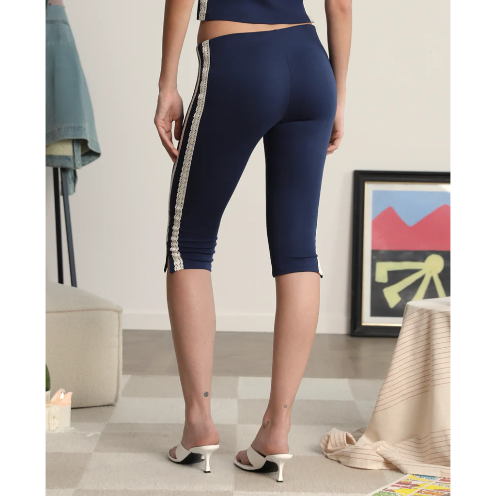 Person wearing navy blue capri leggings with a stripe in a living room setting