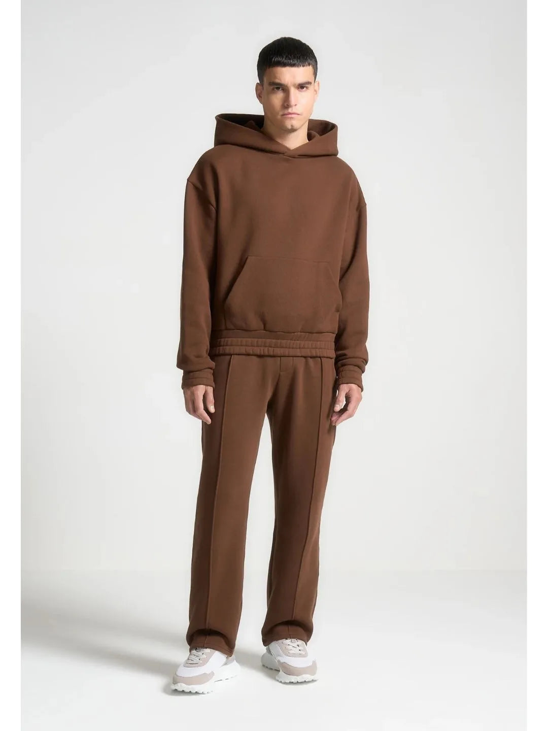 Man wearing a brown tracksuit on a white background