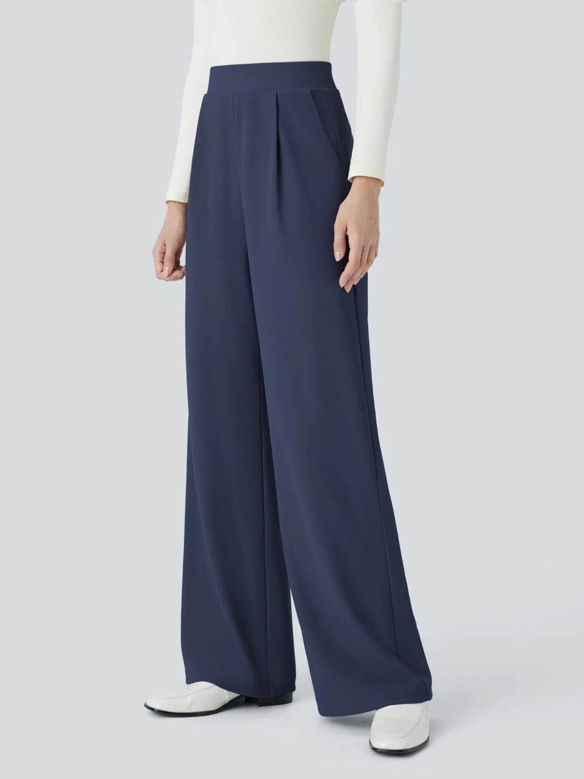 Navy wide-leg pants worn by a person on a light gray background