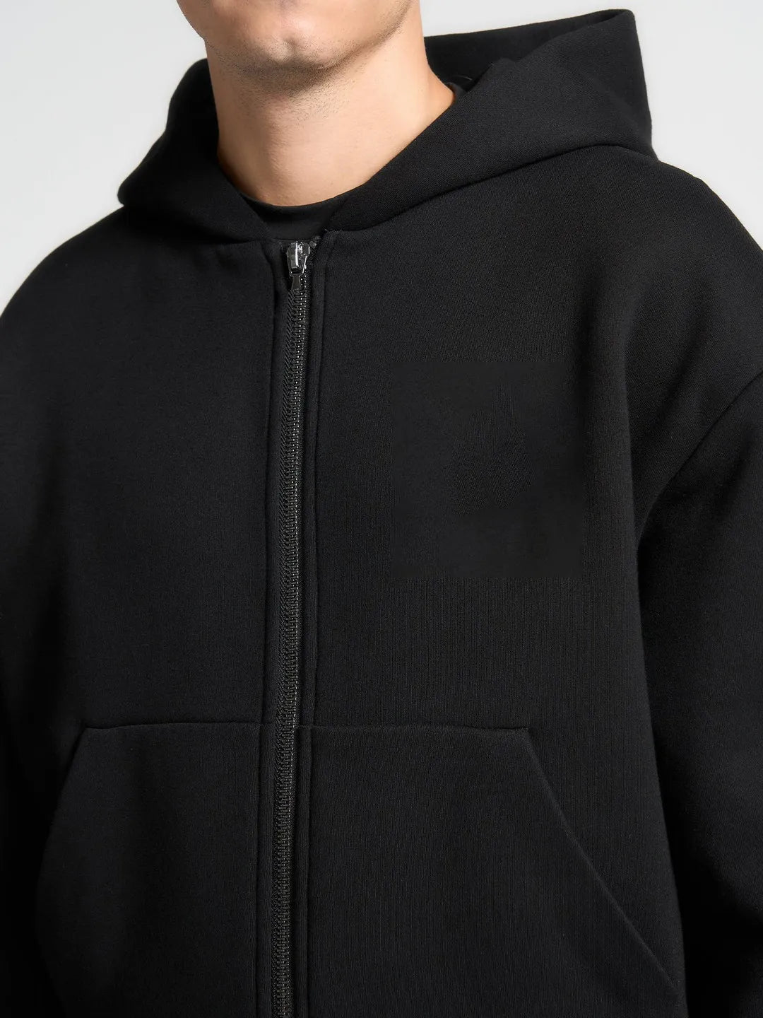 Black hoodie with a zipper on a plain background