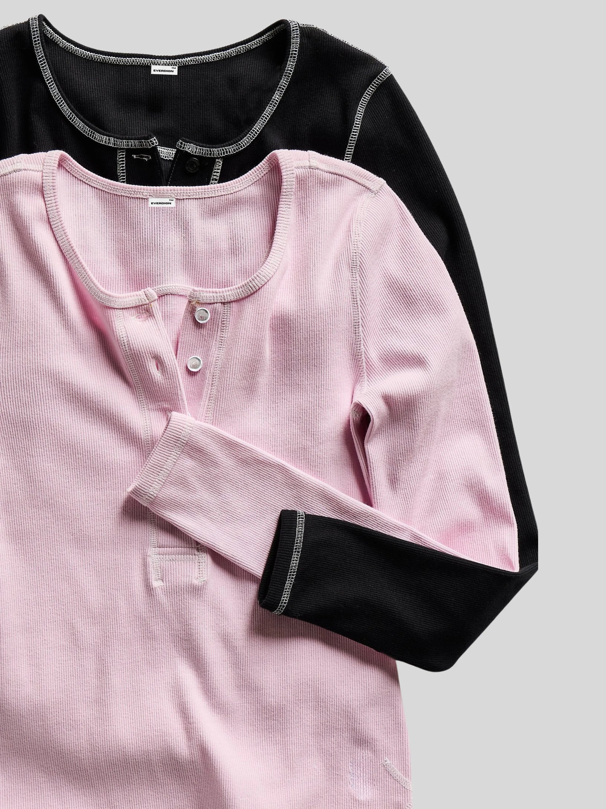 Pink and black long-sleeve shirts on a light gray background