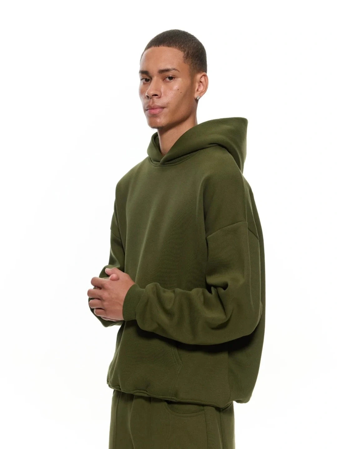 Person wearing an olive green hoodie on a white background