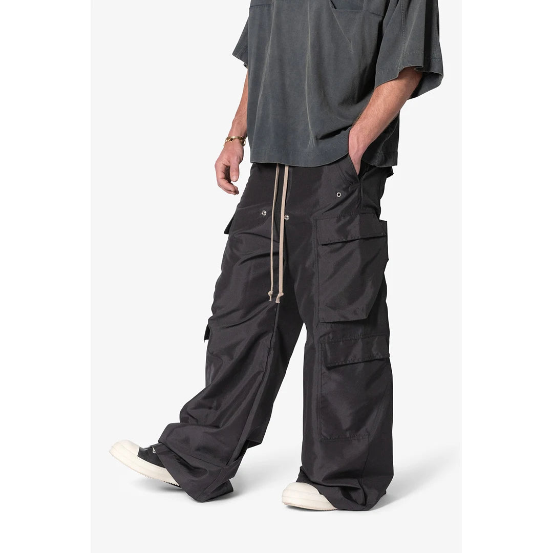 Person wearing black cargo pants and a gray shirt on a white background
