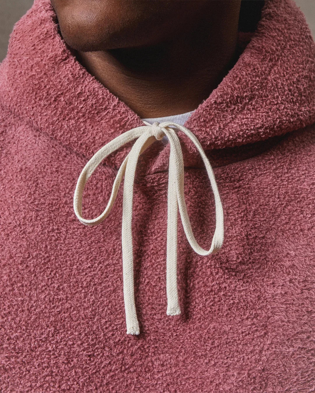 Close-up of a burgundy fleece hoodie with a drawstring