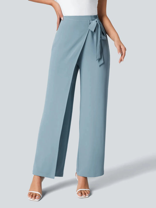 Light blue pants with a tie waist worn by a person on a light gray background
