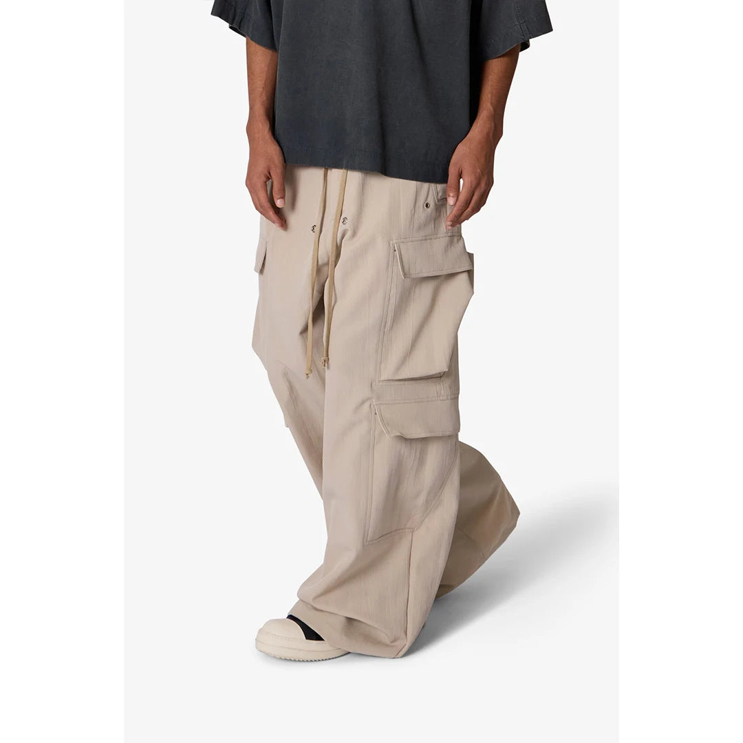 Person wearing beige cargo pants and a black shirt on a white background