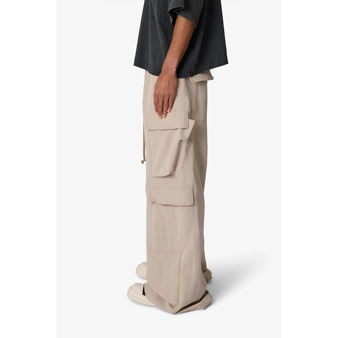 Person wearing beige cargo pants and a dark shirt on a white background