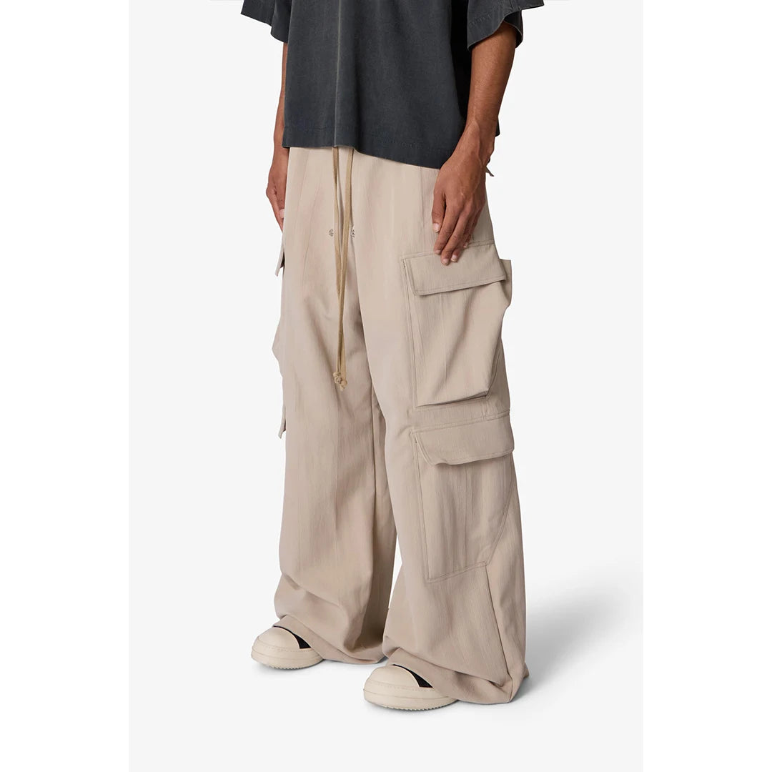 Person wearing beige cargo pants on a white background