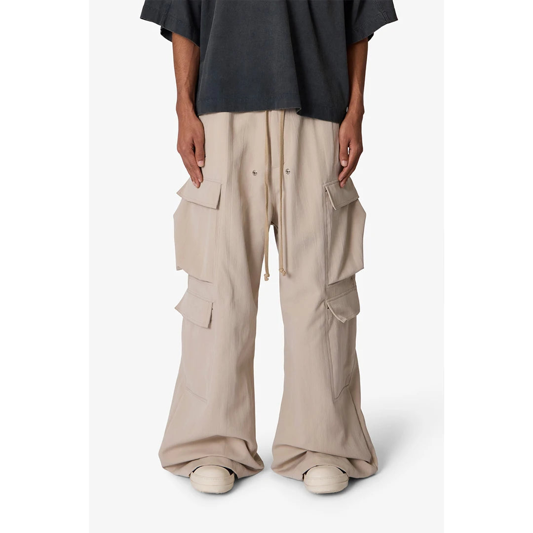 Person wearing beige cargo pants and a black top on a white background