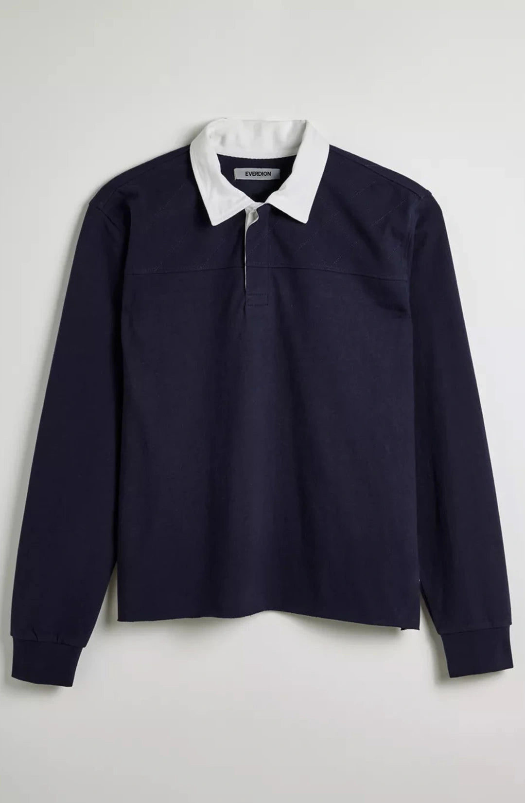 Navy long-sleeve shirt with white collar on a light gray background