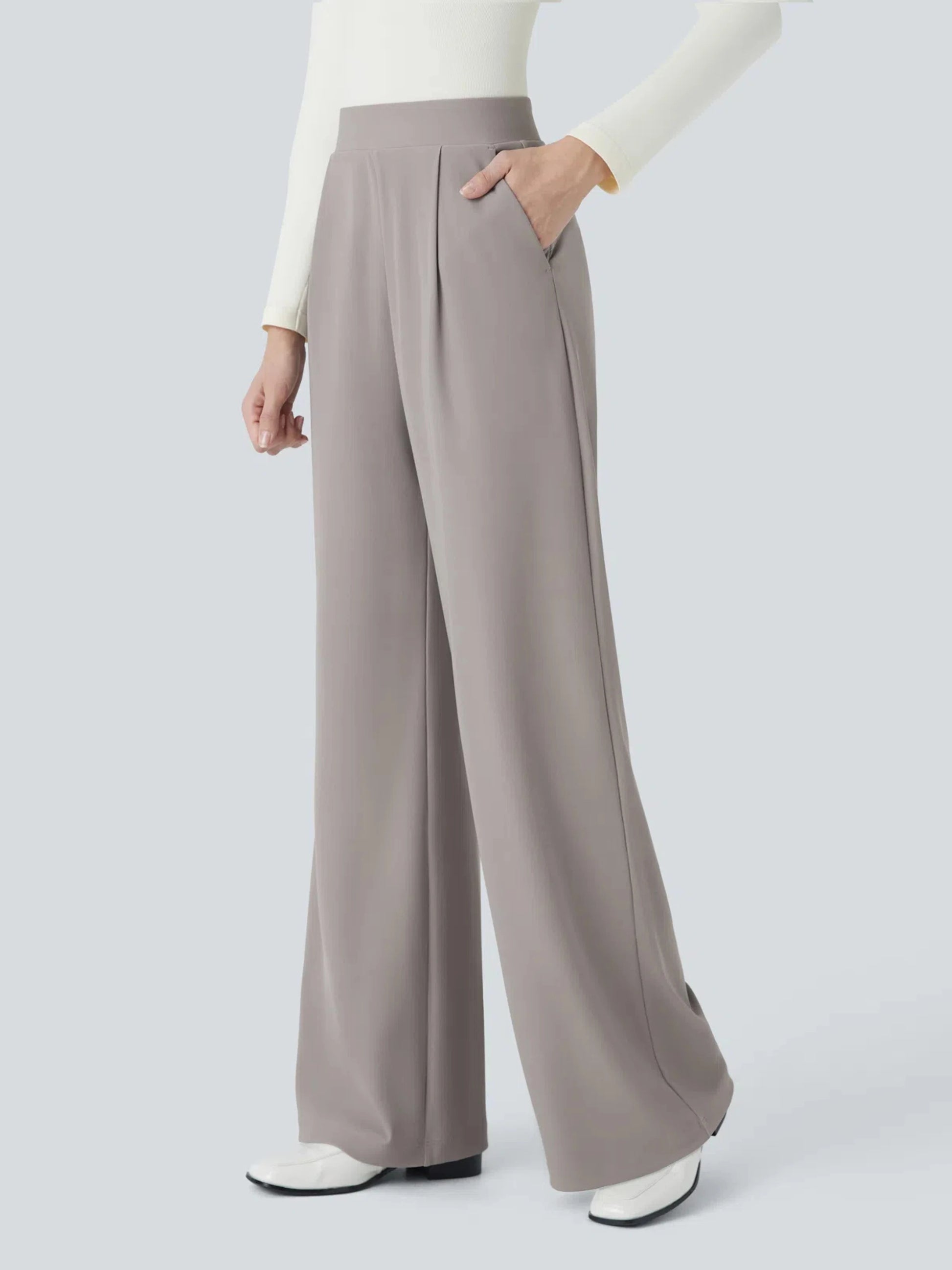 Person wearing light gray wide-leg pants on a white background