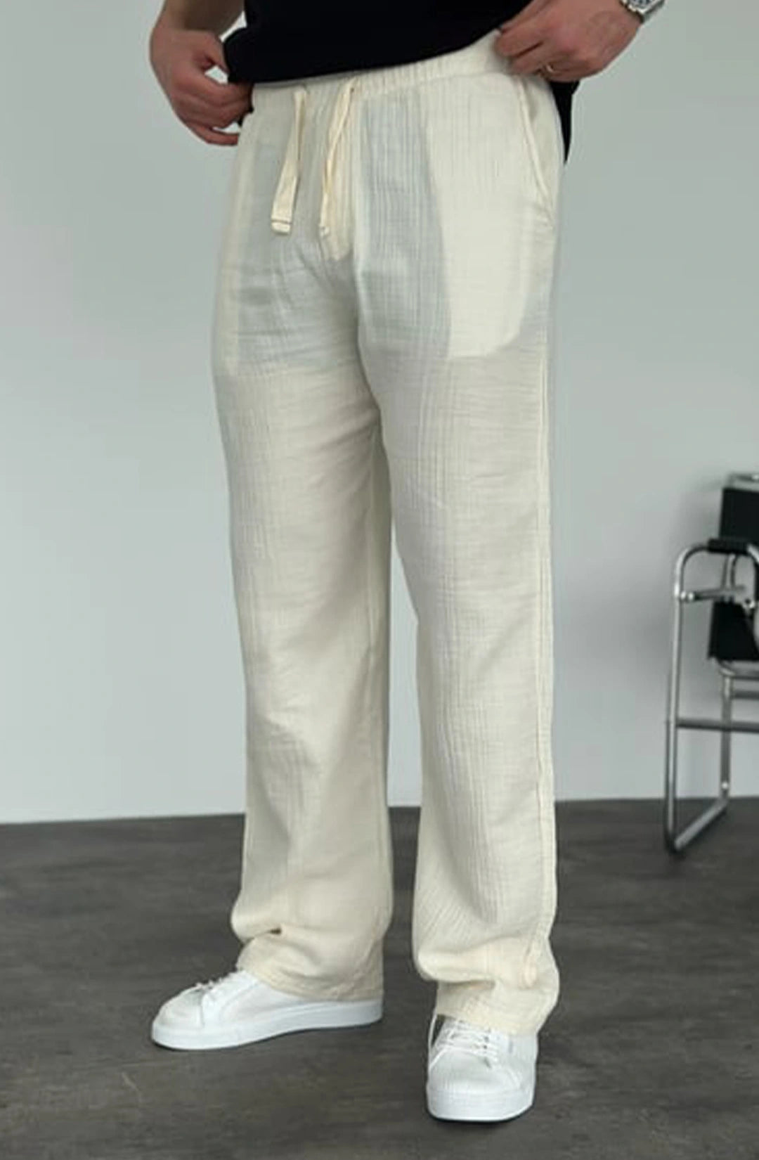 Person wearing light-colored pants with a plain background