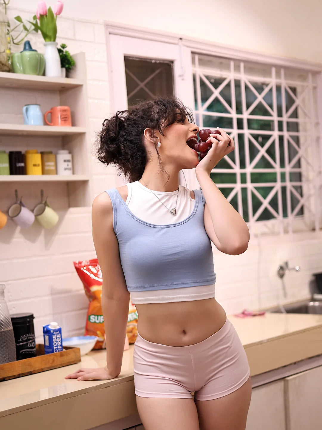 Woman eating grapes in a kitchen