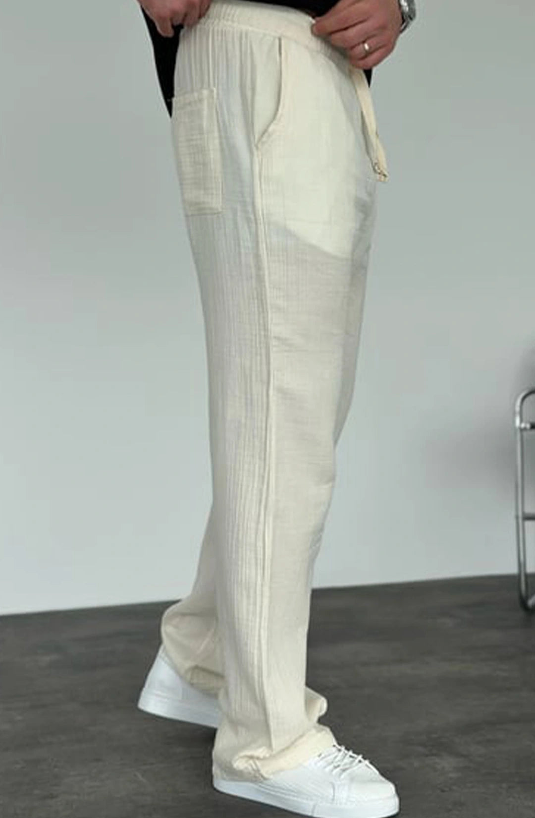 Beige pants worn by a person on a plain background