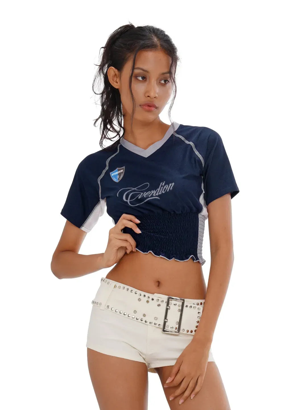 Woman wearing a navy blue sports outfit with white accents on a white background