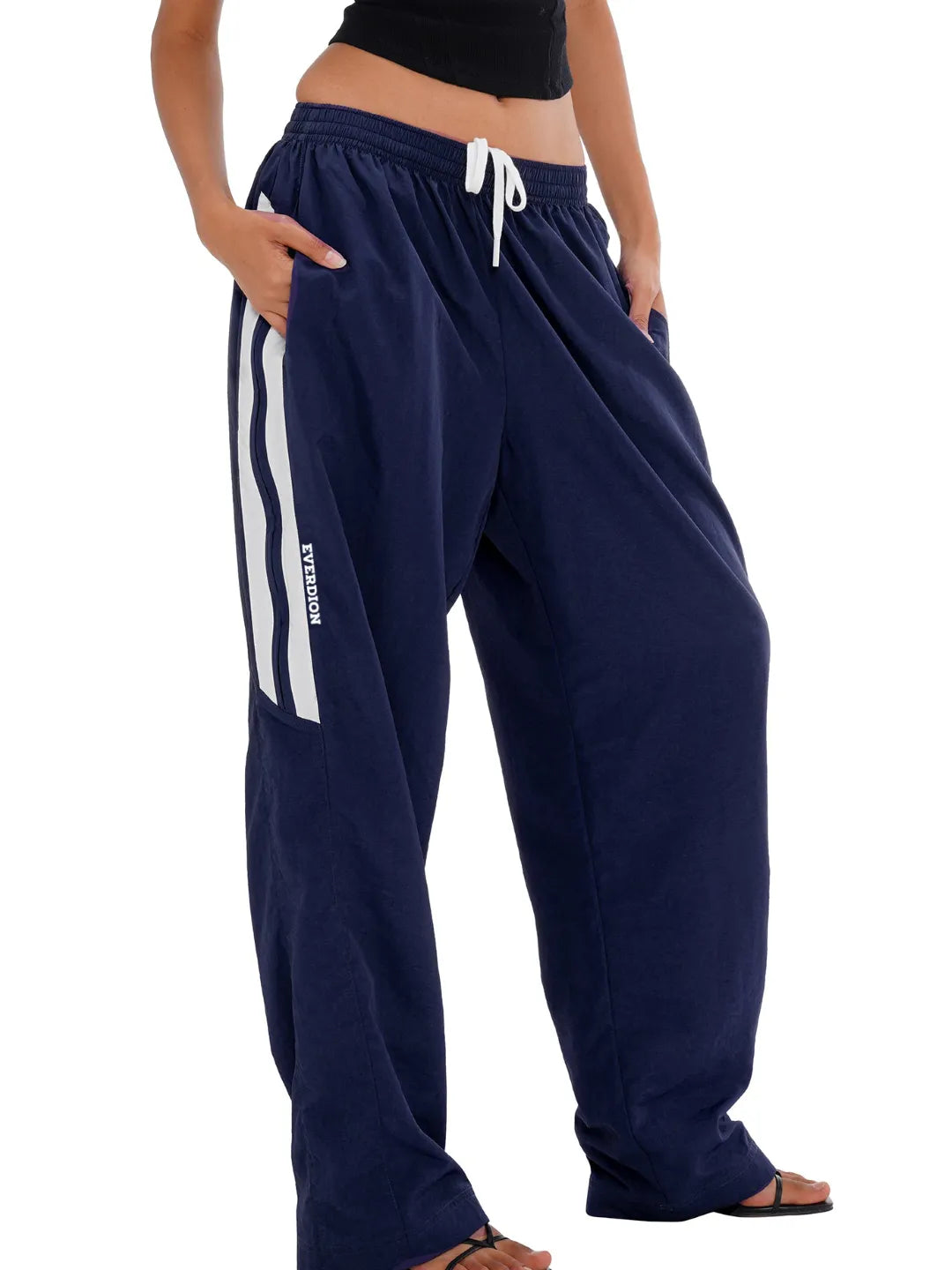 Navy blue sweatpants with white stripes on a white background