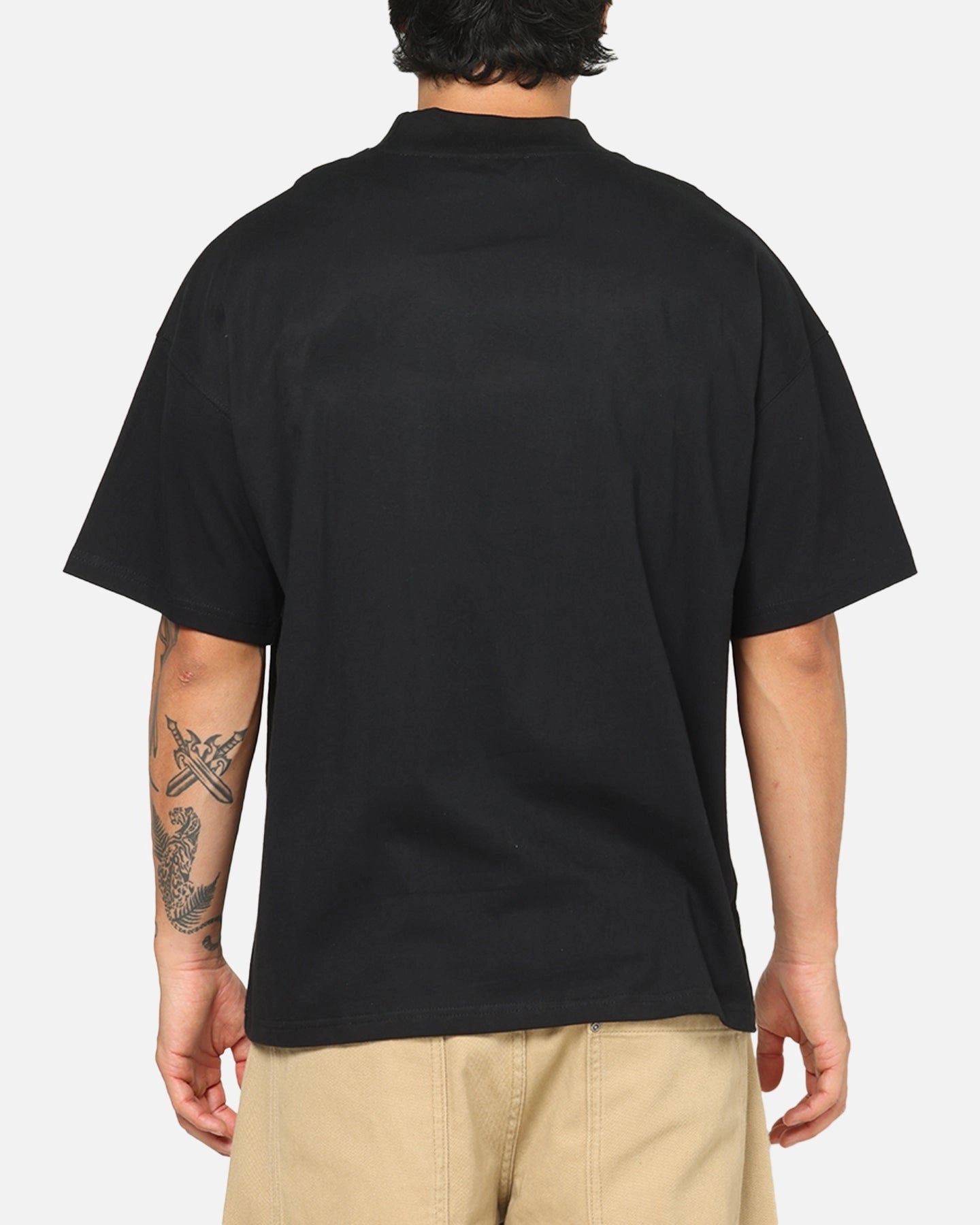 Person wearing a black t-shirt on a plain background