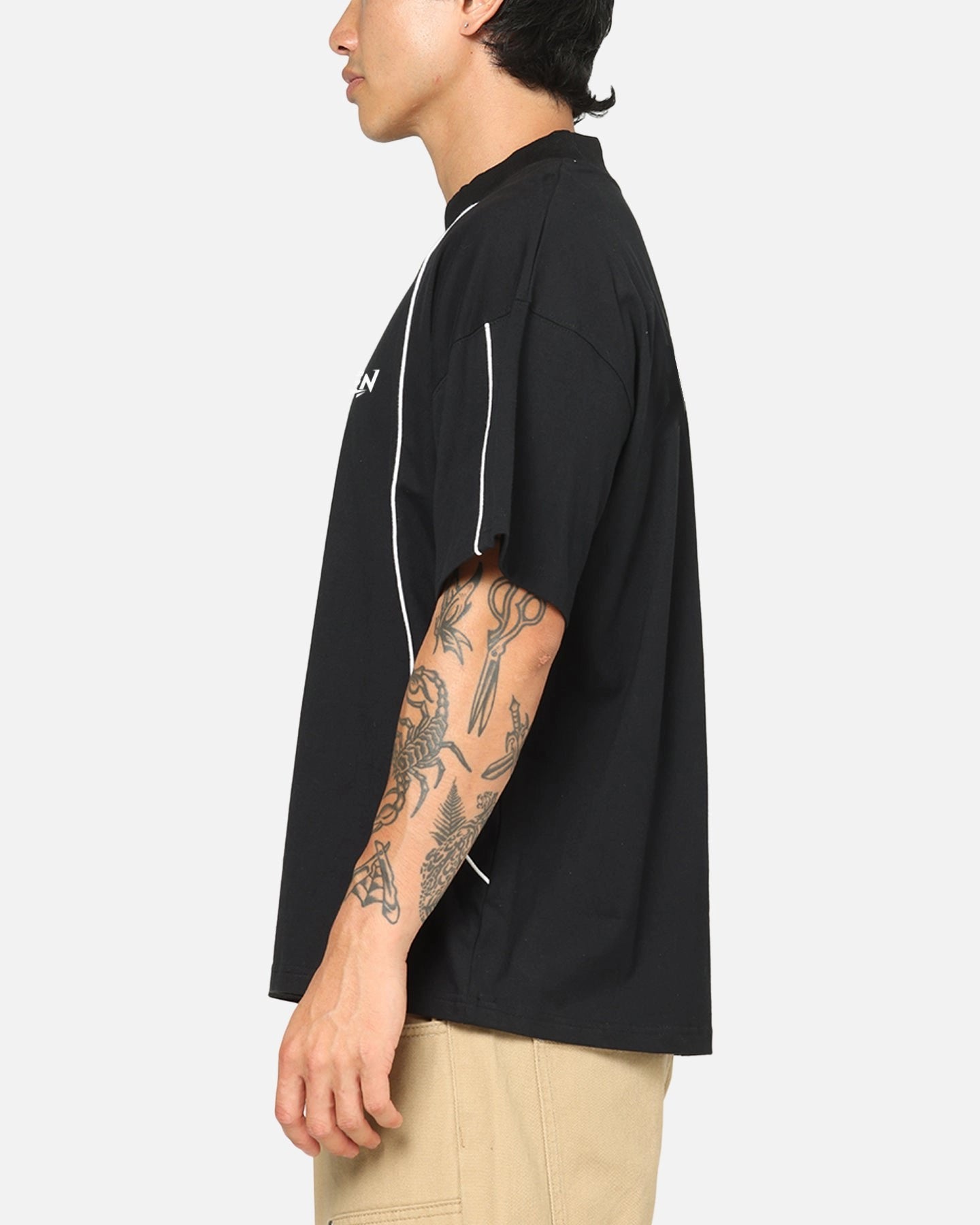 Person wearing a black t-shirt with a brand logo on a white background