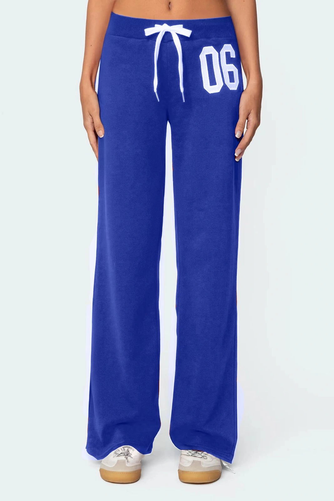 Blue sweatpants with a white drawstring and '06' text on a light grey background