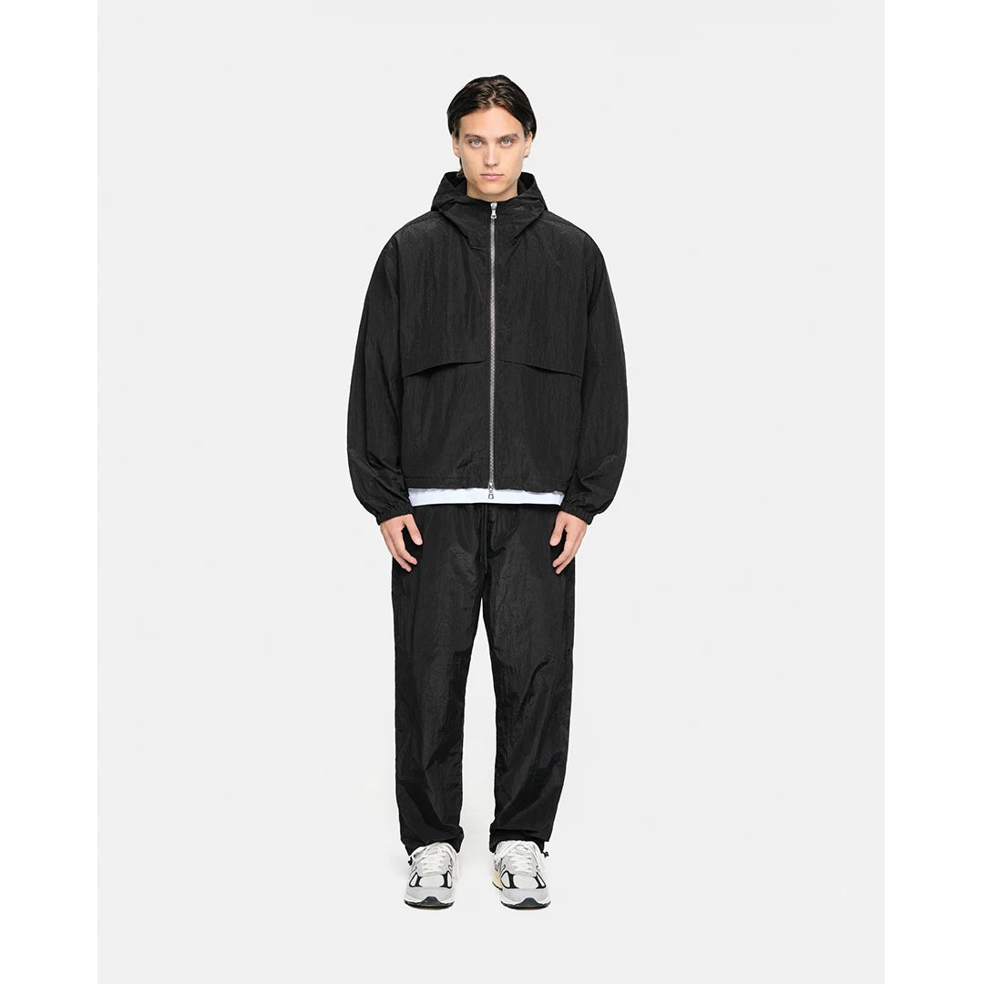 Person wearing a black tracksuit on a white background