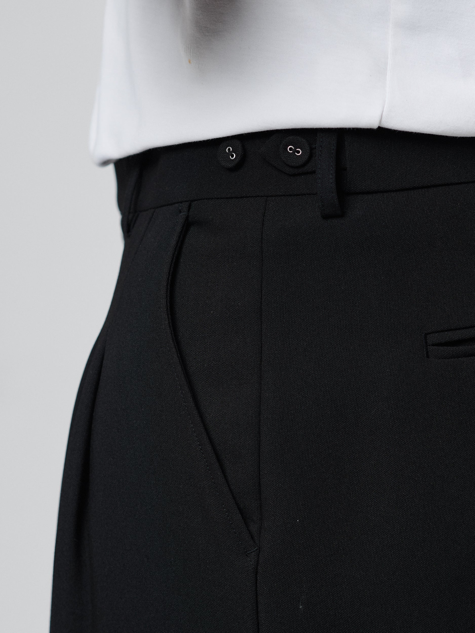 Black Pants with Double front pleats and adjustable side tabs offer a comfortable, customizable fit, while functional pockets and zip-open hem slits add versatility. Crafted from a smooth cotton blend, they are ideal for refined casual, elevated streetwear, and polished off-duty styling.