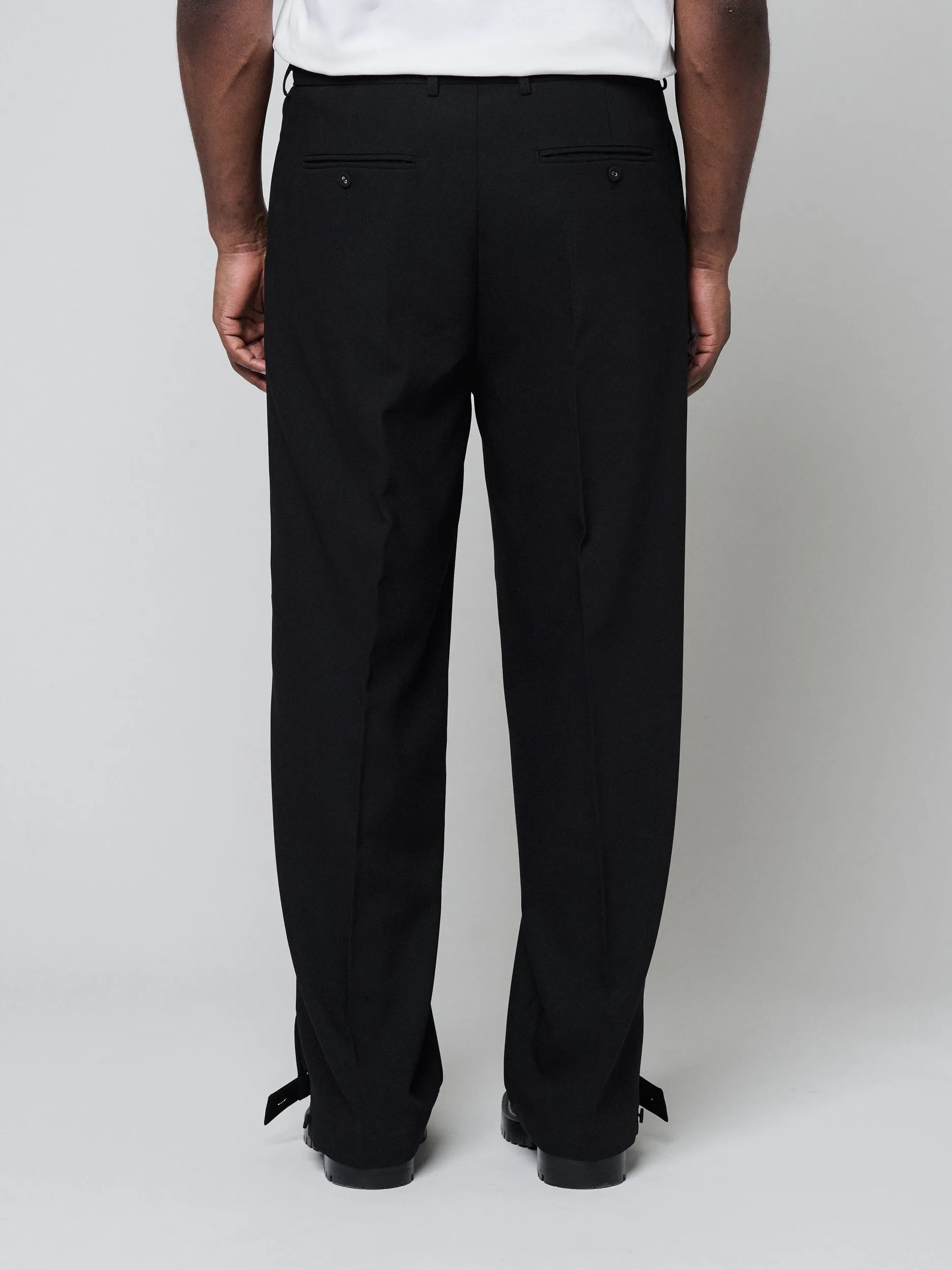 Black Pants with Double front pleats and adjustable side tabs offer a comfortable, customizable fit, while functional pockets and zip-open hem slits add versatility. Crafted from a smooth cotton blend, they are ideal for refined casual, elevated streetwear, and polished off-duty styling.