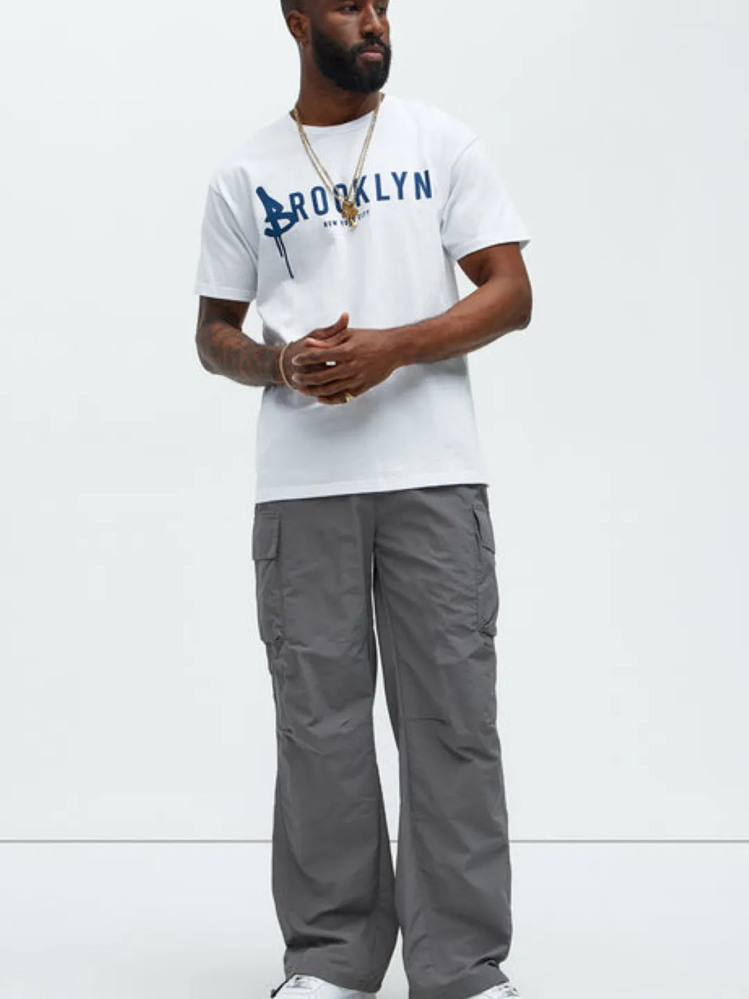 Person wearing gray cargo pants with pockets on a white background
