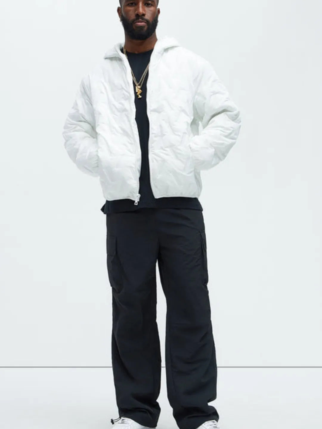 Person wearing black cargo pants with pockets on a white background