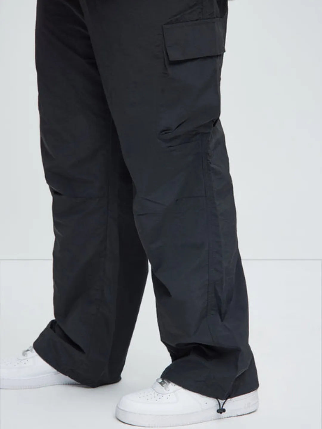 Black cargo pants worn by a person on a white background