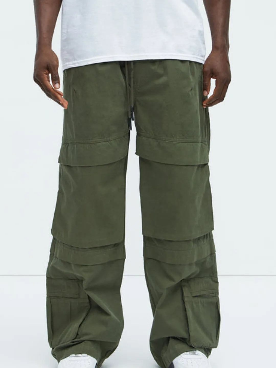 Person wearing a white t-shirt and Green cargo pants on a white background