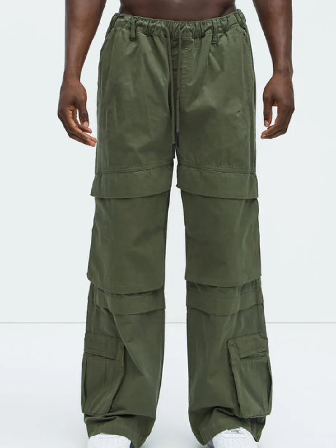 Person wearing a white t-shirt and Green cargo pants on a white background