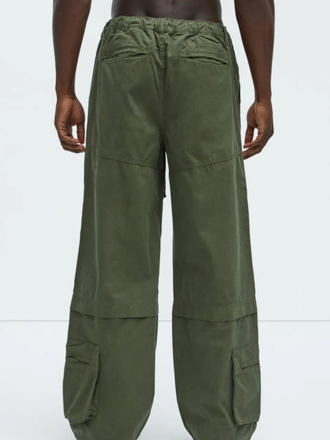 Person wearing a white t-shirt and Green cargo pants on a white background