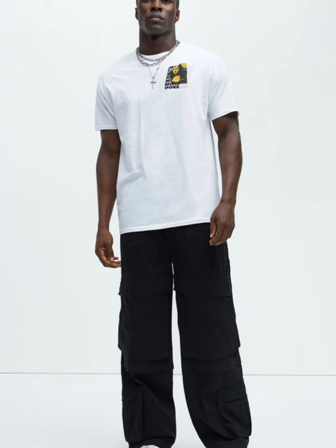 Person wearing a white t-shirt and black  cargo pants on a white background