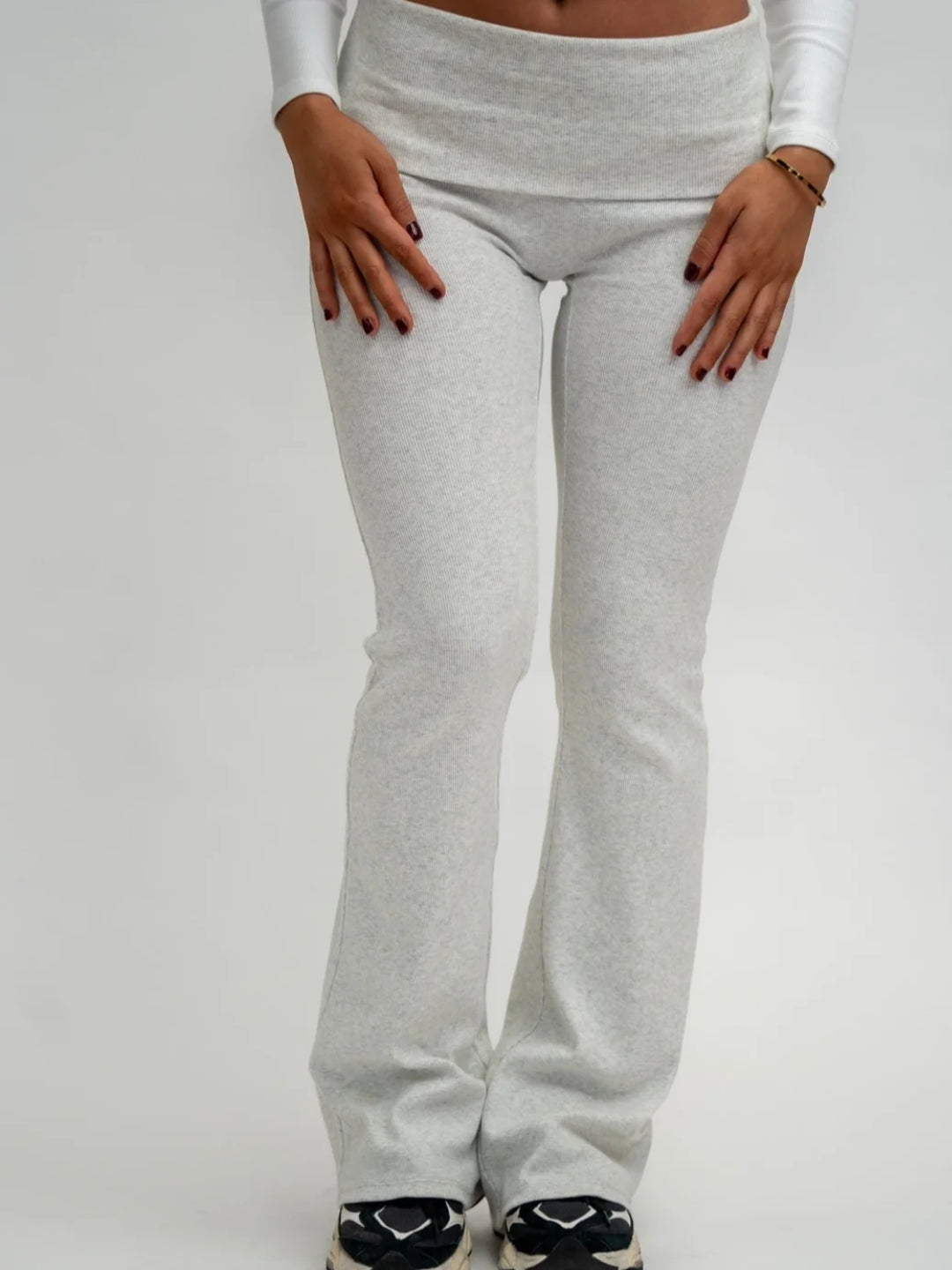 A pair of grey flare leggings on a female model, viewed from the waist down.