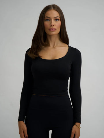 This image features a stylish black long sleeve top, crafted from comfortable lycra fabric. The top, which is form-fitting, showcases a high neck and extends to mid-calf length, providing both a flattering fit and a fashionable look.
