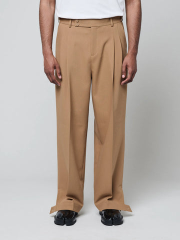 Tan Pants with Double front pleats and adjustable side tabs offer a comfortable, customizable fit, while functional pockets and zip-open hem slits add versatility. Crafted from a smooth cotton blend, they are ideal for refined casual, elevated streetwear, and polished off-duty styling.