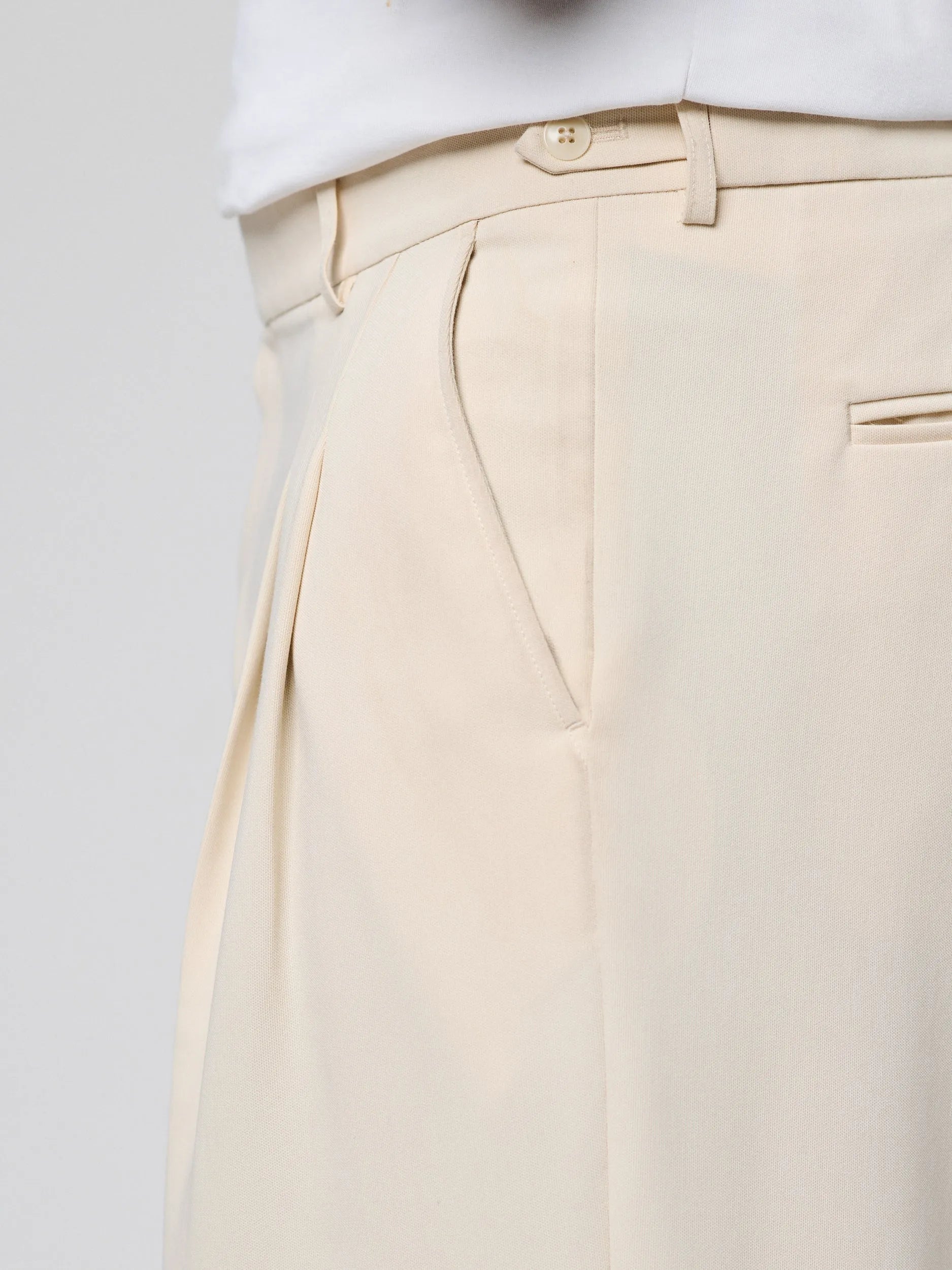 Beige Pants with Double front pleats and adjustable side tabs offer a comfortable, customizable fit, while functional pockets and zip-open hem slits add versatility. Crafted from a smooth cotton blend, they are ideal for refined casual, elevated streetwear, and polished off-duty styling.