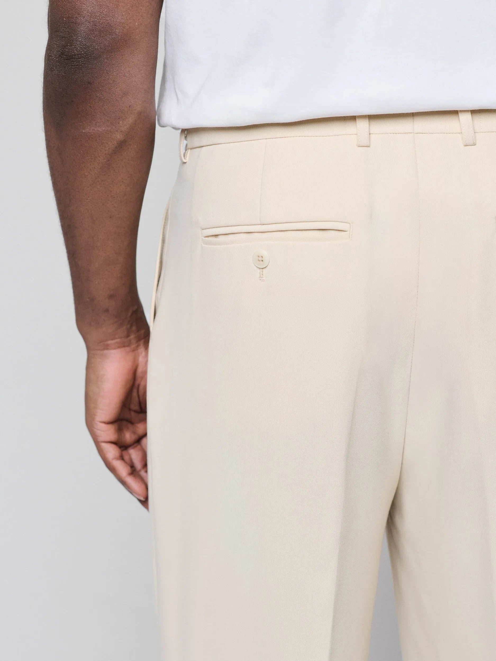 Beige Pants with Double front pleats and adjustable side tabs offer a comfortable, customizable fit, while functional pockets and zip-open hem slits add versatility. Crafted from a smooth cotton blend, they are ideal for refined casual, elevated streetwear, and polished off-duty styling.
