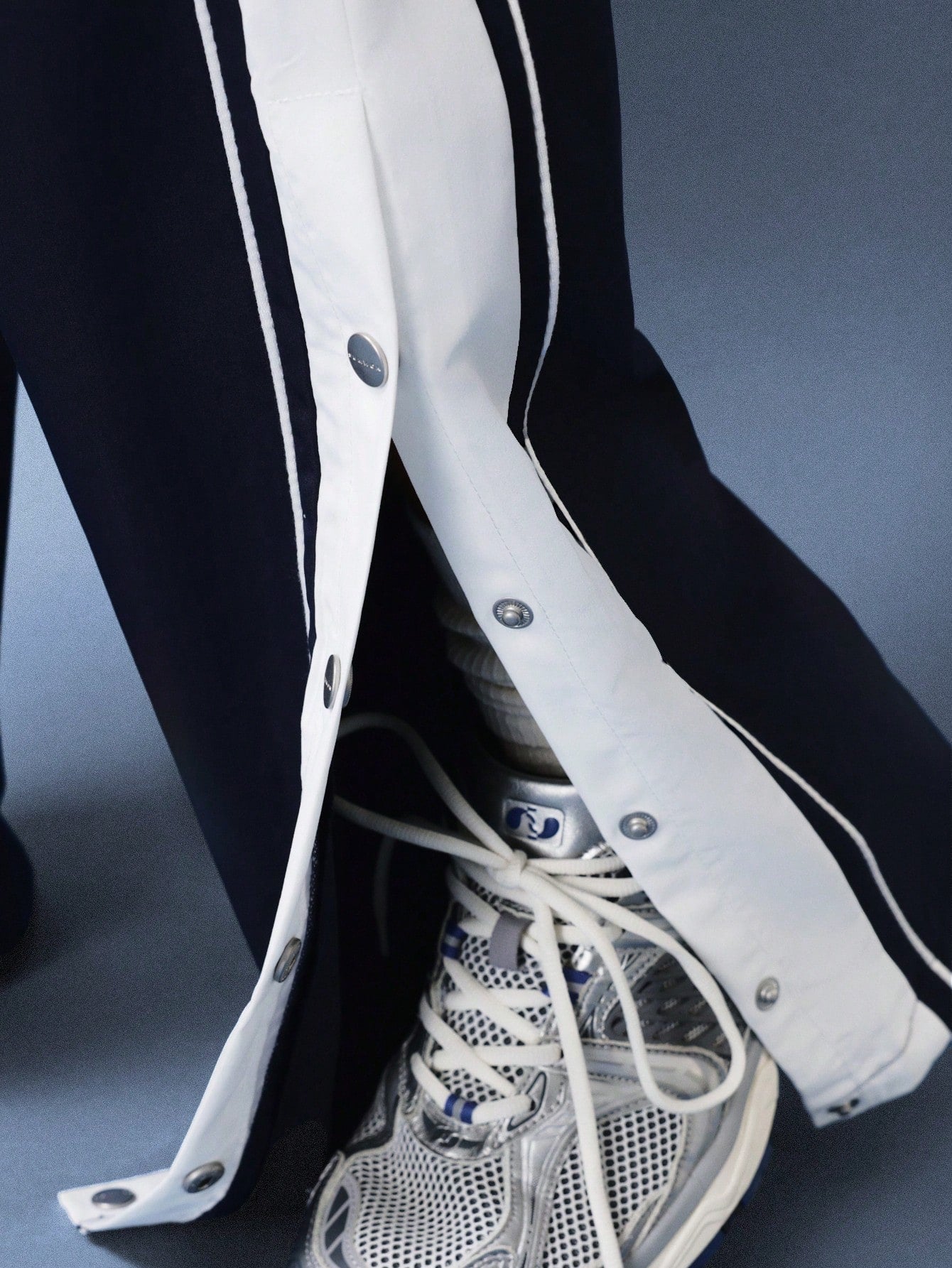 White protective gear on a person's leg with a sneaker, against a dark background