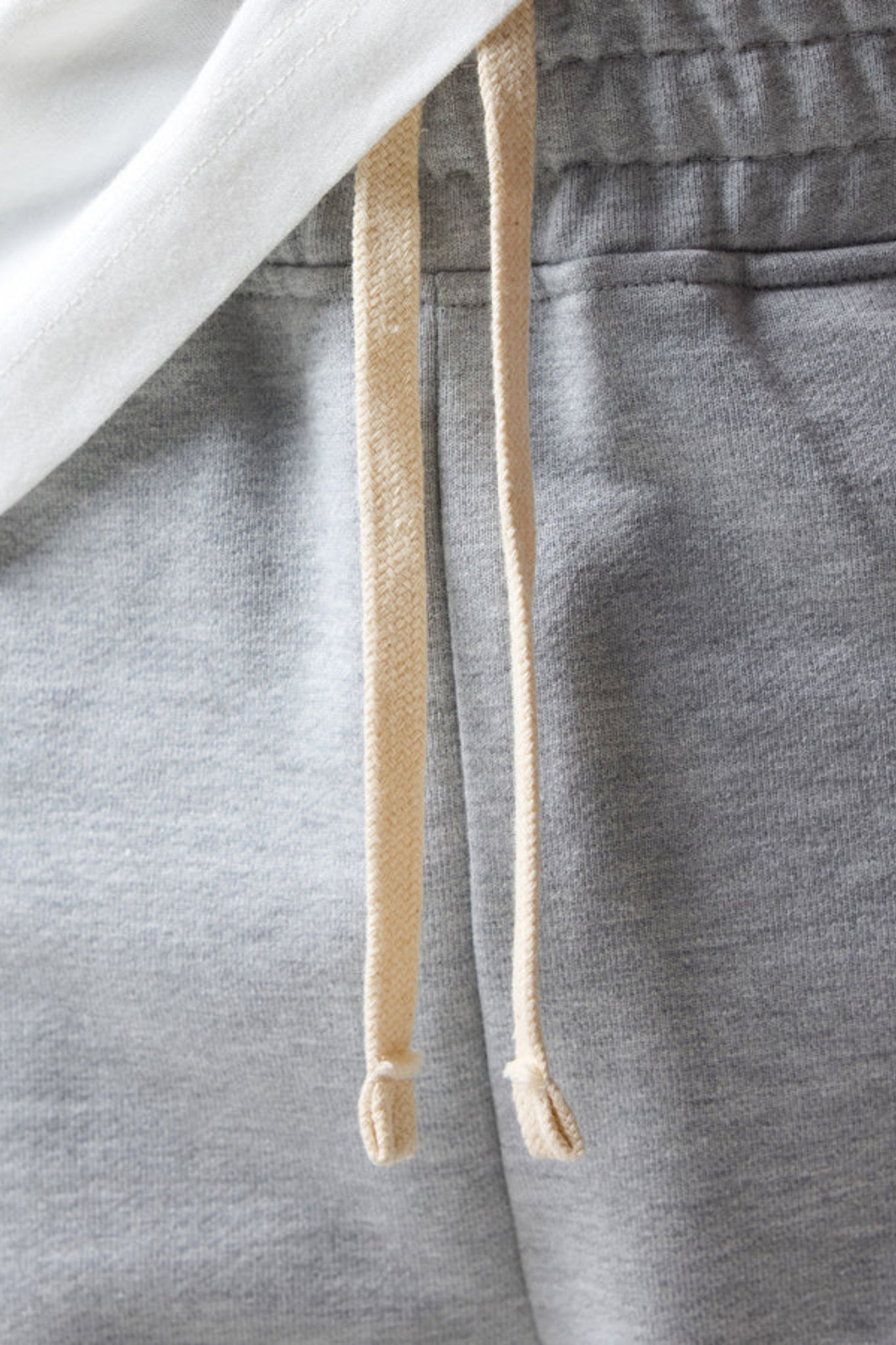 wearing grey open hem joggers with an elastic waistband and drawstring