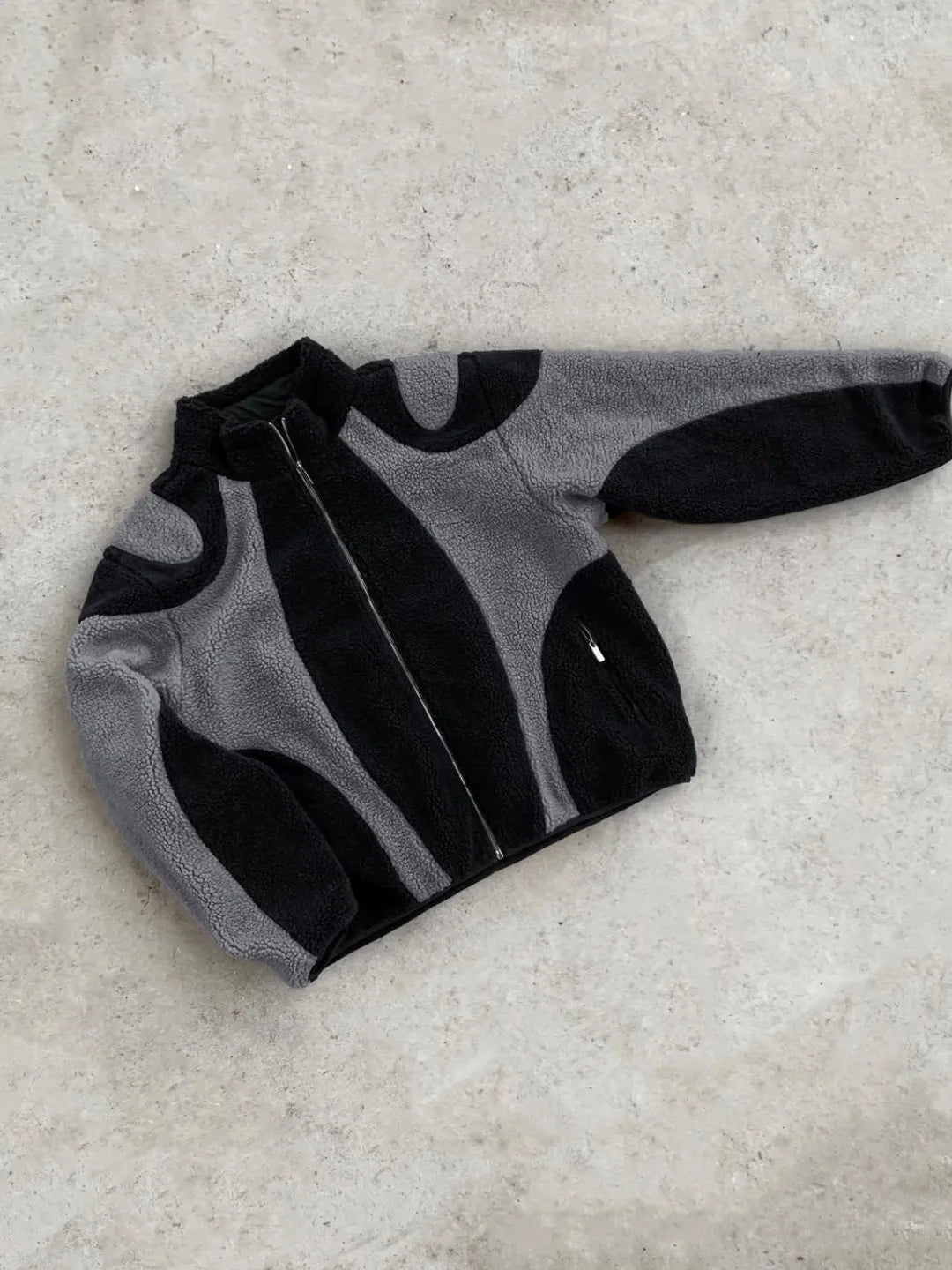 Gray and black jacket on a light grey surface