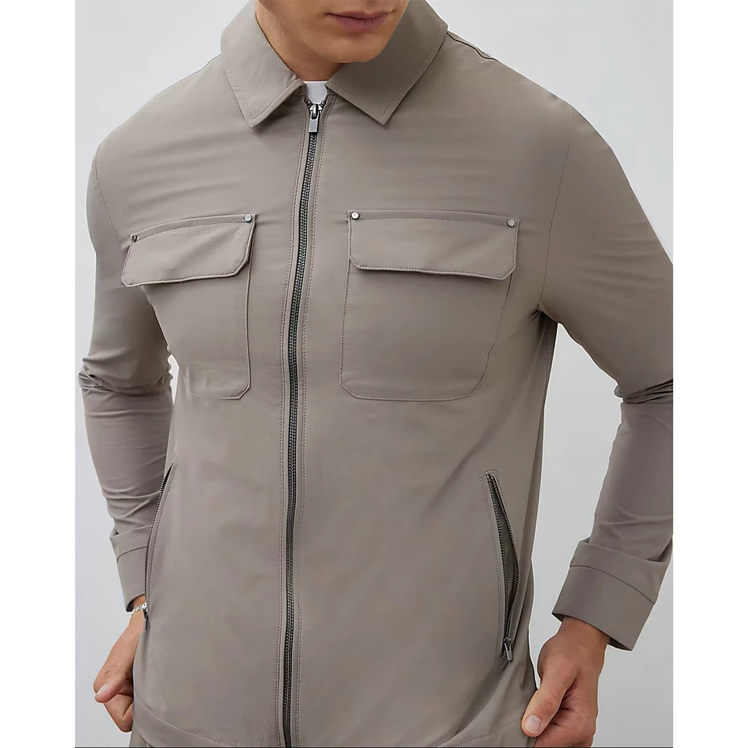 Beige jacket with zippers and pockets on a plain background