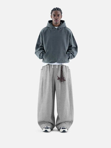 Person wearing a grey hoodie and pants on a white background