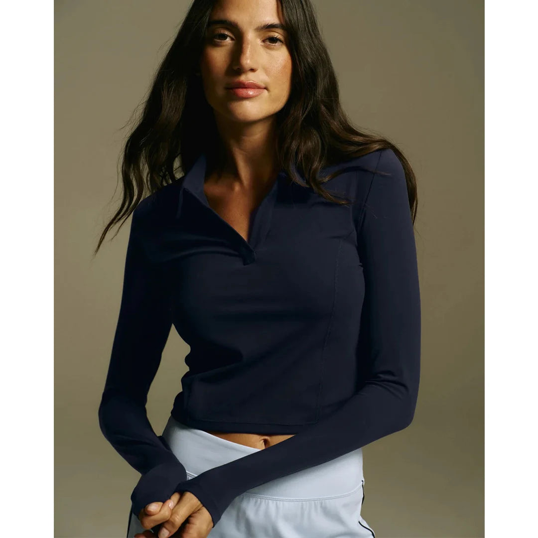 Woman wearing a navy long-sleeve top against a neutral background