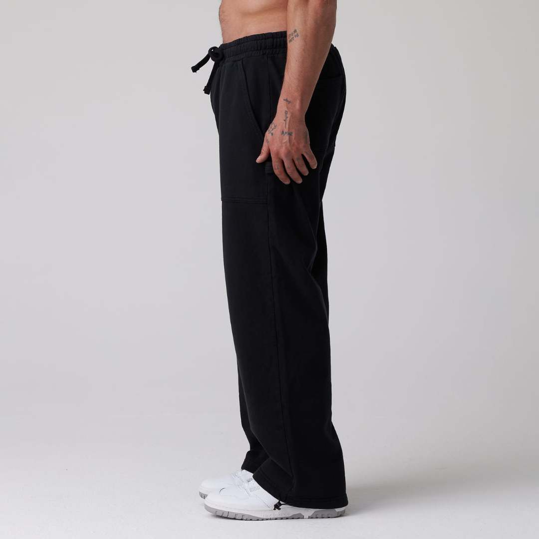 Black jogger pants worn by a person on a plain background