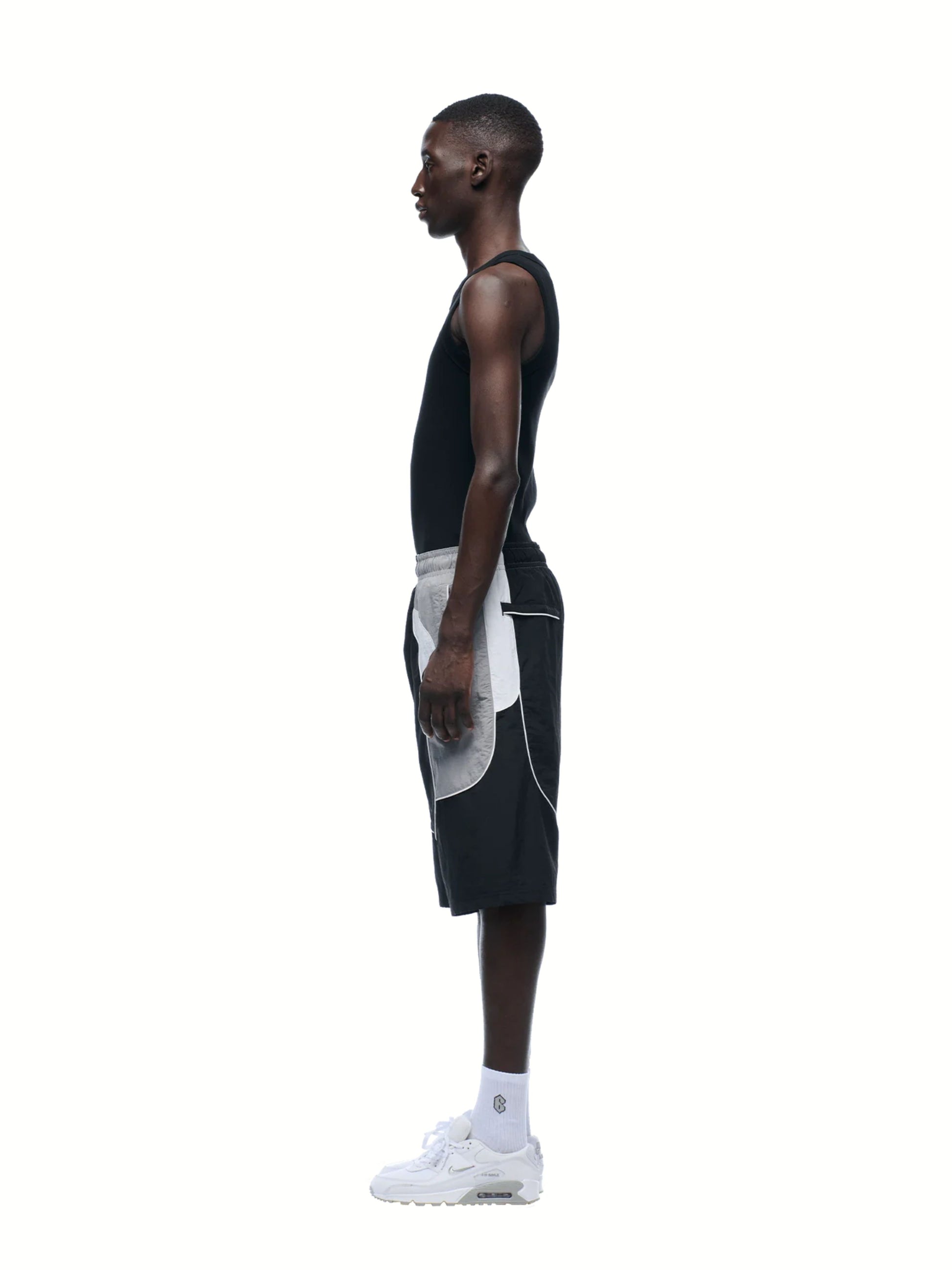 Man wearing a black and white outfit on a white background